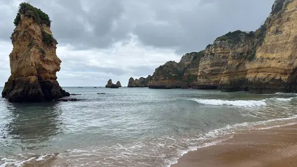 Lagos yakınlarındaki Portekiz 'in Algarve sahil şeridinde güzel sahil kayalıkları, kayalar ve plajlar. Okyanus dalgaları kumtaşı yapıları turistik eğlence mağaraları geziler kumsal hayatı kumları.