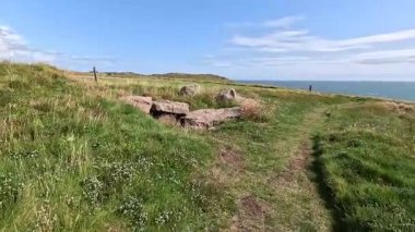 Buchan Bullers uçurumun kenarında yürüyor. Güzel İskoç engebeli kıyı şeridi Kuzey Denizi yamacı yaz güneşinin altında