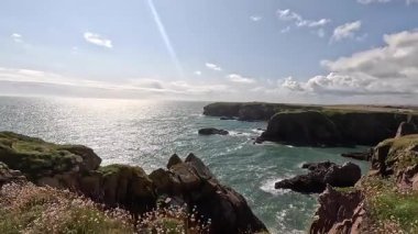 Buchan Bullers uçurumun kenarında yürüyor. Güzel İskoç engebeli kıyı şeridi Kuzey Denizi yamacı yaz güneşinin altında