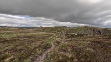 Buchan Bullers uçurumun kenarında yürüyor. Güzel İskoç engebeli kıyı şeridi Kuzey Denizi yamacı yaz güneşinin altında