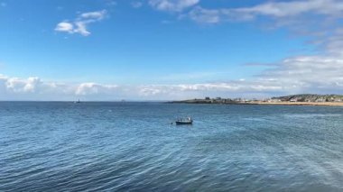 Mavi gökyüzü klasiği İskoç sahil cazibesi ve deniz atmosferi altında Elie Limanı 'na yanaşan tekneler..