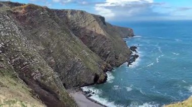 İskoçya 'da Eyemouth ve Burnmouth arasındaki engebeli kayalıklara çarpan dramatik dalgalar, rüzgarlı sahil şeridini kasıp kavuruyor.