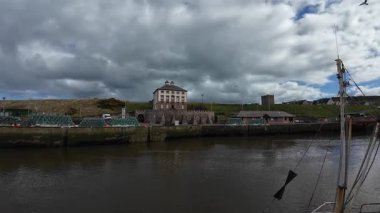 Eyemouth Limanı 'na kıyı manzaralı tekneler yanaştı. Çalışan bir balıkçı limanı ve tarihi deniz cazibesini yansıtıyor.