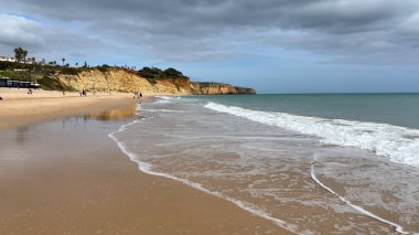 Lagos yakınlarındaki çarpıcı Algarve kıyı şeridi dramatik uçurumlar, altın plajlar, turkuaz sular ve parlak bir gökyüzü altında manzaralı okyanus manzarası.