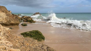 Lagos yakınlarındaki çarpıcı Algarve kıyı şeridi dramatik uçurumlar, altın plajlar, turkuaz sular ve parlak bir gökyüzü altında manzaralı okyanus manzarası.