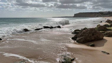 Lagos yakınlarındaki çarpıcı Algarve kıyı şeridi dramatik uçurumlar, altın plajlar, turkuaz sular ve parlak bir gökyüzü altında manzaralı okyanus manzarası.