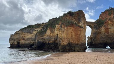 Lagos yakınlarındaki çarpıcı Algarve kıyı şeridi dramatik uçurumlar, altın plajlar, turkuaz sular ve parlak bir gökyüzü altında manzaralı okyanus manzarası.