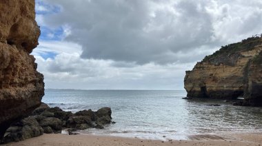 Lagos yakınlarındaki çarpıcı Algarve kıyı şeridi dramatik uçurumlar, altın plajlar, turkuaz sular ve parlak bir gökyüzü altında manzaralı okyanus manzarası.