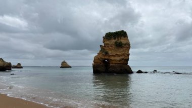 Lagos yakınlarındaki çarpıcı Algarve kıyı şeridi dramatik uçurumlar, altın plajlar, turkuaz sular ve parlak bir gökyüzü altında manzaralı okyanus manzarası.