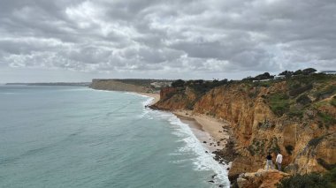 Lagos yakınlarındaki çarpıcı Algarve kıyı şeridi dramatik uçurumlar, altın plajlar, turkuaz sular ve parlak bir gökyüzü altında manzaralı okyanus manzarası.
