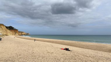Lagos yakınlarındaki çarpıcı Algarve kıyı şeridi dramatik uçurumlar, altın plajlar, turkuaz sular ve parlak bir gökyüzü altında manzaralı okyanus manzarası.