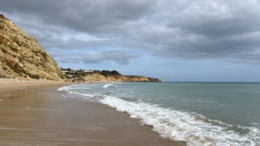 Lagos yakınlarındaki çarpıcı Algarve kıyı şeridi dramatik uçurumlar, altın plajlar, turkuaz sular ve parlak bir gökyüzü altında manzaralı okyanus manzarası.