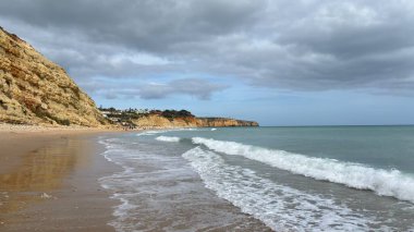 Lagos yakınlarındaki çarpıcı Algarve kıyı şeridi dramatik uçurumlar, altın plajlar, turkuaz sular ve parlak bir gökyüzü altında manzaralı okyanus manzarası.