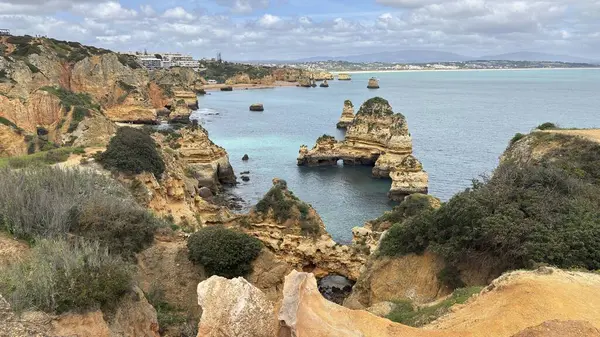 Lagos yakınlarındaki çarpıcı Algarve kıyı şeridi dramatik uçurumlar, altın plajlar, turkuaz sular ve parlak bir gökyüzü altında manzaralı okyanus manzarası.