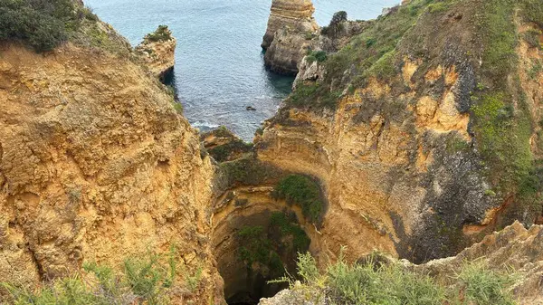 Lagos yakınlarındaki çarpıcı Algarve kıyı şeridi dramatik uçurumlar, altın plajlar, turkuaz sular ve parlak bir gökyüzü altında manzaralı okyanus manzarası.