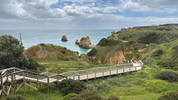 Lagos yakınlarındaki çarpıcı Algarve kıyı şeridi dramatik uçurumlar, altın plajlar, turkuaz sular ve parlak bir gökyüzü altında manzaralı okyanus manzarası.