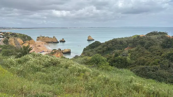 Lagos yakınlarındaki çarpıcı Algarve kıyı şeridi dramatik uçurumlar, altın plajlar, turkuaz sular ve parlak bir gökyüzü altında manzaralı okyanus manzarası.