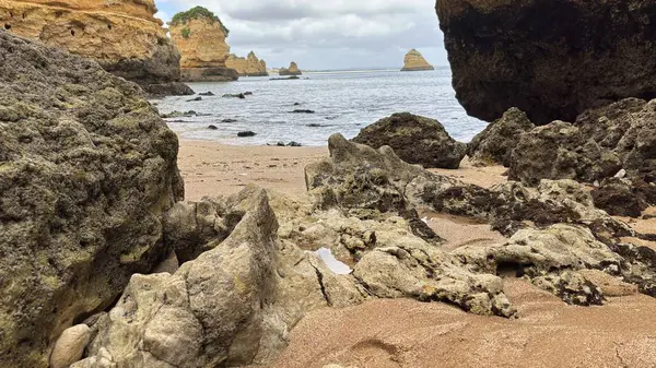 Lagos yakınlarındaki çarpıcı Algarve kıyı şeridi dramatik uçurumlar, altın plajlar, turkuaz sular ve parlak bir gökyüzü altında manzaralı okyanus manzarası.