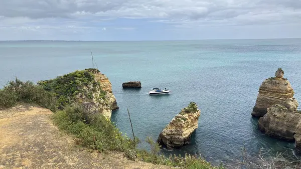Lagos yakınlarındaki çarpıcı Algarve kıyı şeridi dramatik uçurumlar, altın plajlar, turkuaz sular ve parlak bir gökyüzü altında manzaralı okyanus manzarası.