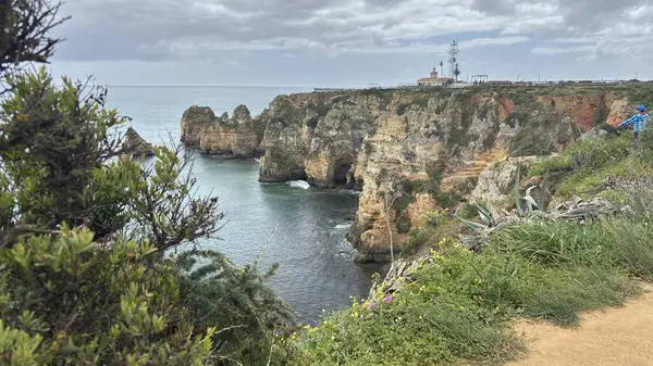 Lagos yakınlarındaki çarpıcı Algarve kıyı şeridi dramatik uçurumlar, altın plajlar, turkuaz sular ve parlak bir gökyüzü altında manzaralı okyanus manzarası.