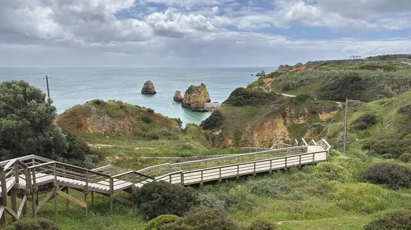 Lagos yakınlarındaki çarpıcı Algarve kıyı şeridi dramatik uçurumlar, altın plajlar, turkuaz sular ve parlak bir gökyüzü altında manzaralı okyanus manzarası.
