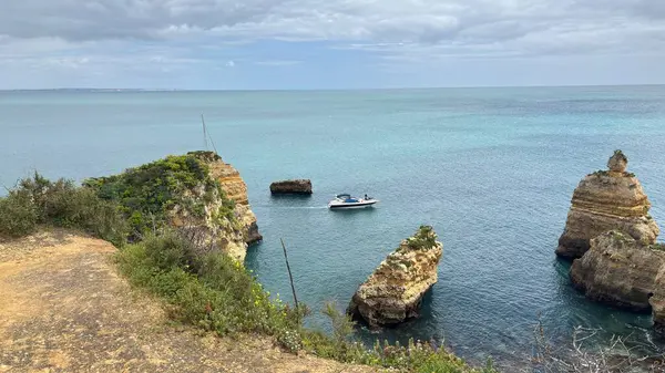 Lagos yakınlarındaki çarpıcı Algarve kıyı şeridi dramatik uçurumlar, altın plajlar, turkuaz sular ve parlak bir gökyüzü altında manzaralı okyanus manzarası.