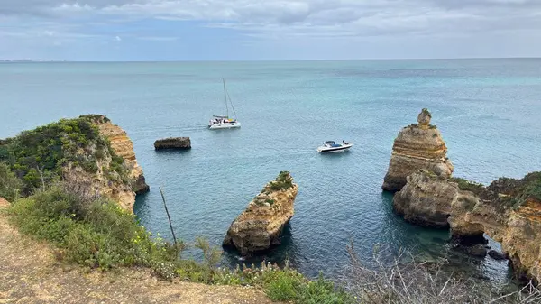 Lagos yakınlarındaki çarpıcı Algarve kıyı şeridi dramatik uçurumlar, altın plajlar, turkuaz sular ve parlak bir gökyüzü altında manzaralı okyanus manzarası.