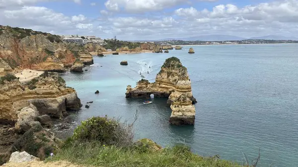 Lagos yakınlarındaki çarpıcı Algarve kıyı şeridi dramatik uçurumlar, altın plajlar, turkuaz sular ve parlak bir gökyüzü altında manzaralı okyanus manzarası.