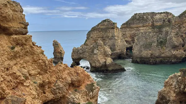 Lagos yakınlarındaki çarpıcı Algarve kıyı şeridi dramatik uçurumlar, altın plajlar, turkuaz sular ve parlak bir gökyüzü altında manzaralı okyanus manzarası.