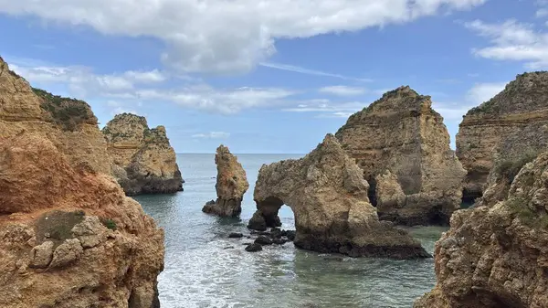 Lagos yakınlarındaki çarpıcı Algarve kıyı şeridi dramatik uçurumlar, altın plajlar, turkuaz sular ve parlak bir gökyüzü altında manzaralı okyanus manzarası.