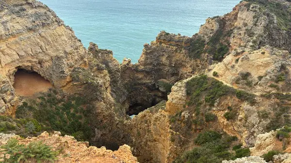 Lagos yakınlarındaki çarpıcı Algarve kıyı şeridi dramatik uçurumlar, altın plajlar, turkuaz sular ve parlak bir gökyüzü altında manzaralı okyanus manzarası.