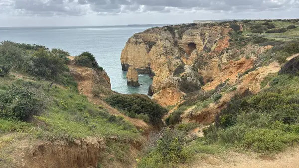 Lagos yakınlarındaki çarpıcı Algarve kıyı şeridi dramatik uçurumlar, altın plajlar, turkuaz sular ve parlak bir gökyüzü altında manzaralı okyanus manzarası.