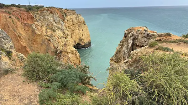 Lagos yakınlarındaki çarpıcı Algarve kıyı şeridi dramatik uçurumlar, altın plajlar, turkuaz sular ve parlak bir gökyüzü altında manzaralı okyanus manzarası.