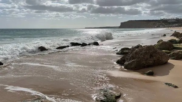 Lagos yakınlarındaki çarpıcı Algarve kıyı şeridi dramatik uçurumlar, altın plajlar, turkuaz sular ve parlak bir gökyüzü altında manzaralı okyanus manzarası.
