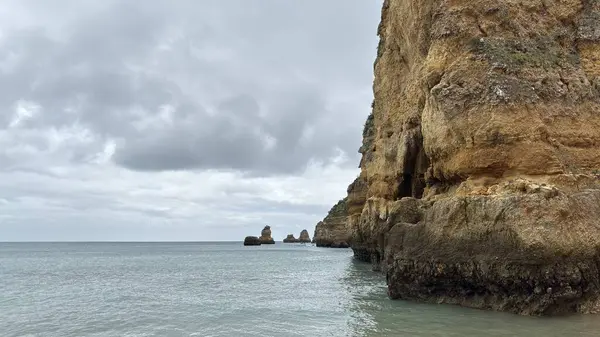 Lagos yakınlarındaki çarpıcı Algarve kıyı şeridi dramatik uçurumlar, altın plajlar, turkuaz sular ve parlak bir gökyüzü altında manzaralı okyanus manzarası.