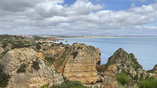 Lagos yakınlarındaki çarpıcı Algarve kıyı şeridi dramatik uçurumlar, altın plajlar, turkuaz sular ve parlak bir gökyüzü altında manzaralı okyanus manzarası.