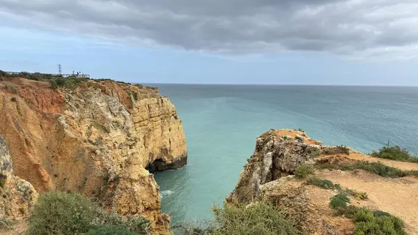Lagos yakınlarındaki çarpıcı Algarve kıyı şeridi dramatik uçurumlar, altın plajlar, turkuaz sular ve parlak bir gökyüzü altında manzaralı okyanus manzarası.