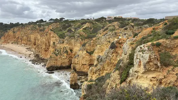 Lagos yakınlarındaki çarpıcı Algarve kıyı şeridi dramatik uçurumlar, altın plajlar, turkuaz sular ve parlak bir gökyüzü altında manzaralı okyanus manzarası.