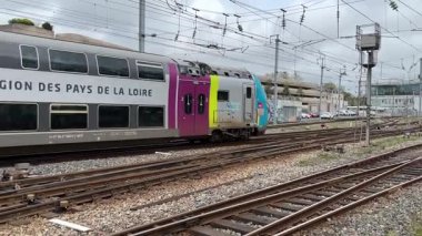 SNCF yolcu trenleri Nantes 'ta çalışır, kalabalık bir şehir ortamında Fransız demiryolu seyahatleri, toplu taşımacılık ve kentsel hareketlilik sergilerler..