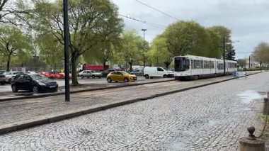 Nantes kentsel caddelerinde faaliyet gösteren modern Fransız yolcu tramvaylarının sokak seviyesindeki görüntüsü günlük hareketle toplu taşımayı gösteriyor.