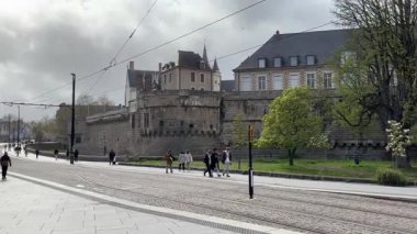 Nantes kentsel caddelerinde faaliyet gösteren modern Fransız yolcu tramvaylarının sokak seviyesindeki görüntüsü günlük hareketle toplu taşımayı gösteriyor.