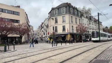Nantes kentsel caddelerinde faaliyet gösteren modern Fransız yolcu tramvaylarının sokak seviyesindeki görüntüsü günlük hareketle toplu taşımayı gösteriyor.