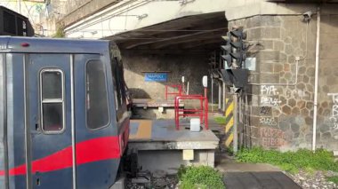 İtalyan yolcu trenleri istasyonlarda ve Napoli 'deki raylar boyunca hareket halinde, güneydeki bir şehir merkezinde toplu taşıma ve demiryolu ulaşımını yakalıyor.