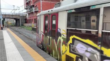 İtalyan yolcu trenleri istasyonlarda ve Napoli 'deki raylar boyunca hareket halinde, güneydeki bir şehir merkezinde toplu taşıma ve demiryolu ulaşımını yakalıyor.