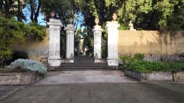 Napoli 'deki Reggia di Portici' nin huzurlu bahçeleri yemyeşil, yürüyüş yolları ve manzaralı kraliyet peyzajı.