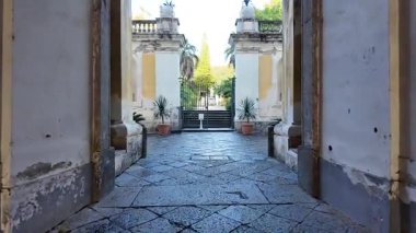 Napoli 'deki Reggia di Portici' nin huzurlu bahçeleri yemyeşil, yürüyüş yolları ve manzaralı kraliyet peyzajı.