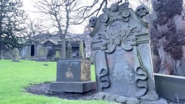 Edinburgh 'daki St. Cuthberts Kirkyard' ın atmosferik görüntüleri. Edinburgh Kalesi 'nin altındaki tarihi bir mezarlık. İçinde antik mezar taşları, bir gözetleme kulesi ve zengin bir miras var..