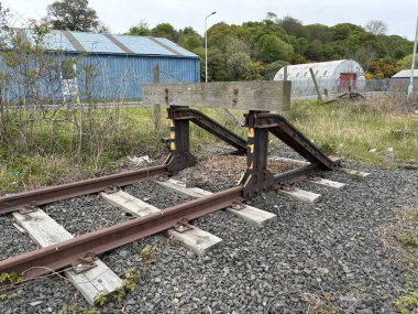 Yıpranmış demiryolu tampon durağı, sanayi bölgesinde kullanılmayan bir kaplamanın sona erdiğini gösteriyor.