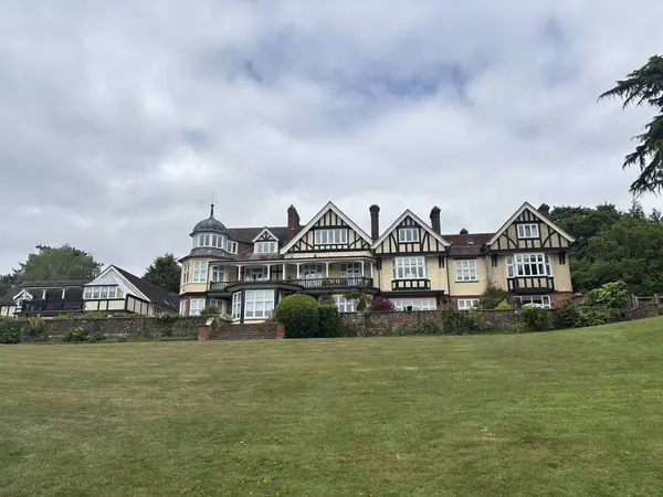 Yazın çiçek açan ön bahçesi olan büyüleyici bir İngiliz kır evi. Çevresi yeşillik, çiçekler ve huzurlu kırsal bölgelerle çevrili klasik kırsal mimari.