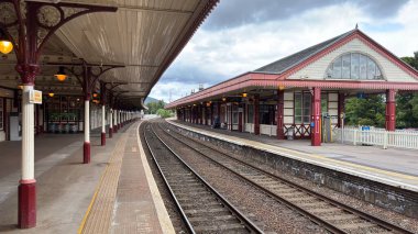 Aviemore tren istasyonu, bir yük treni ve buharlı bir lokomotifle modern seyahatle İskoçya 'nın tarihi cazibesini harmanlıyor..